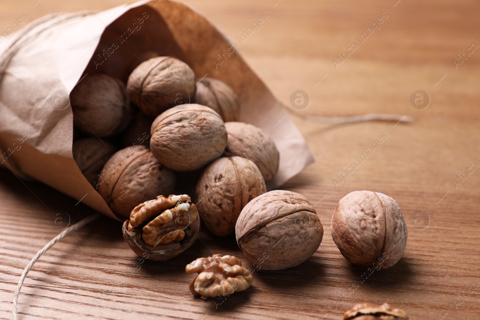 Photo of Tasty walnuts on wooden table, closeup view