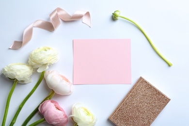 Photo of Composition with ranunculus flowers, paper, ribbon and notebook on white background