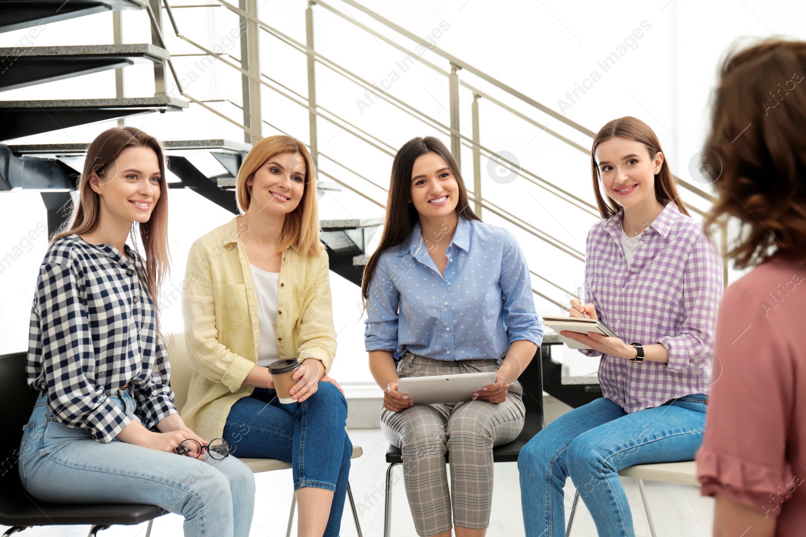 Photo of Female coach working with ladies in room. Women power concept