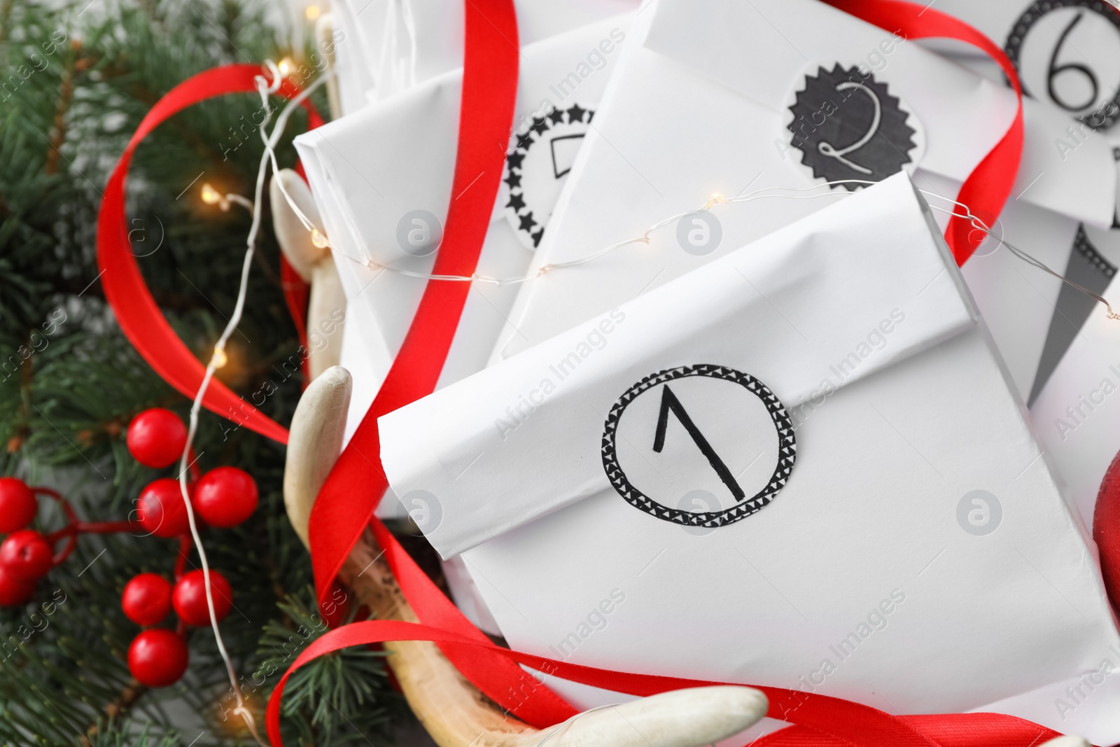 Photo of Paper bags and festive decor, closeup. Christmas advent calendar