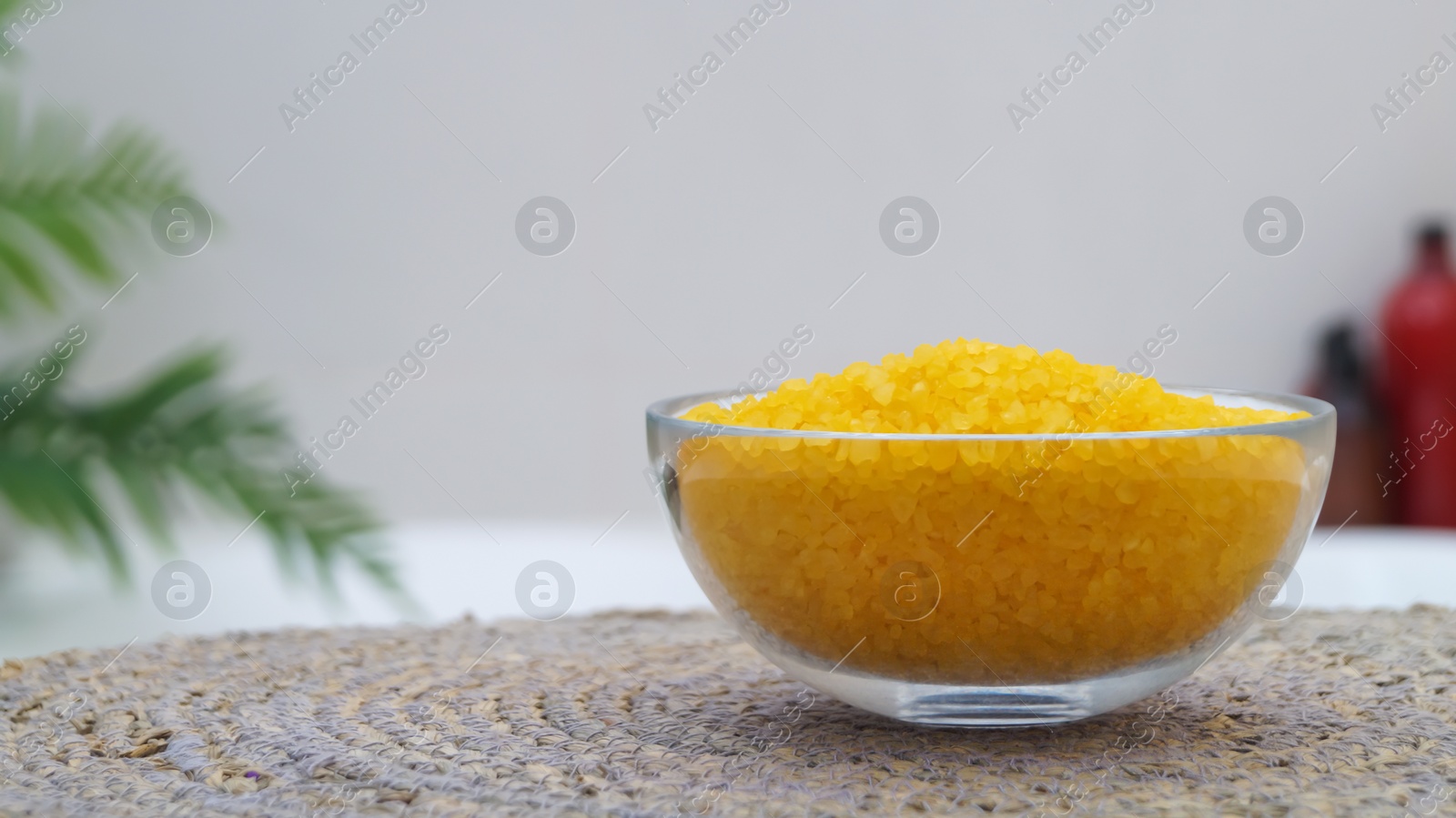 Photo of Bowl with bath salt on wicker mat in bathroom, closeup. Space for text
