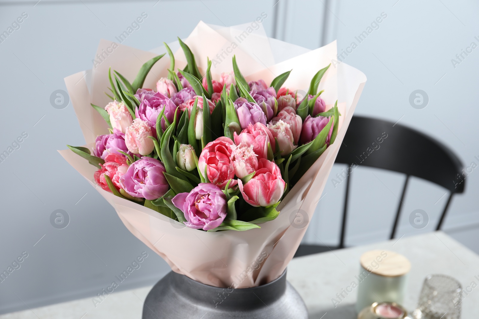 Photo of Vase with bouquet of beautiful tulips on table indoors, closeup