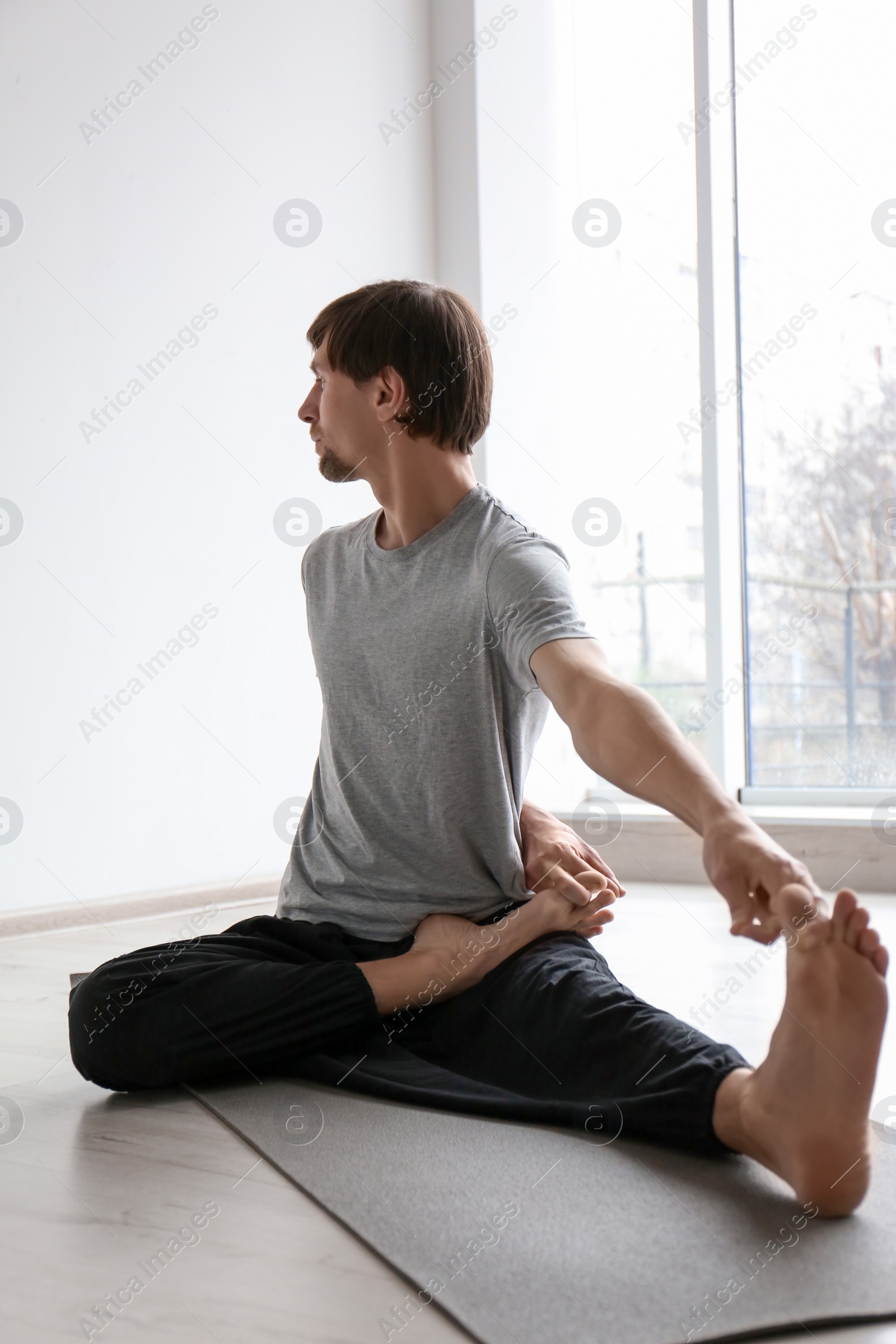 Photo of Young man practicing yoga indoors