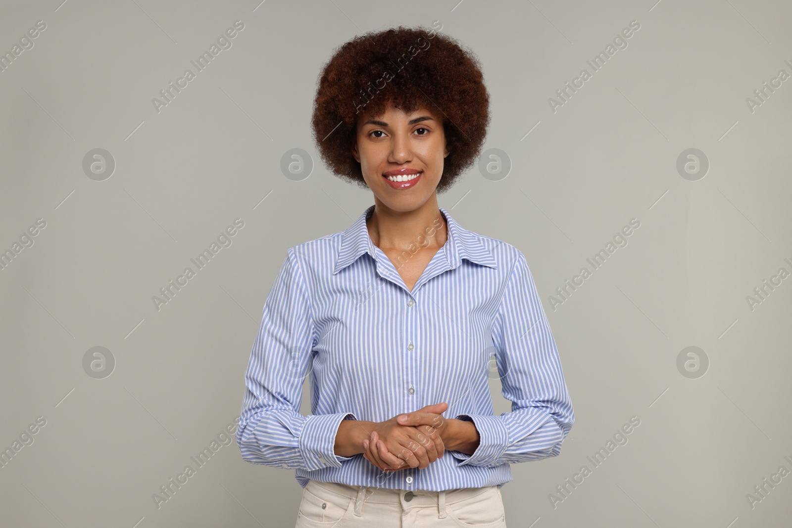 Photo of Portrait of happy young woman on grey background