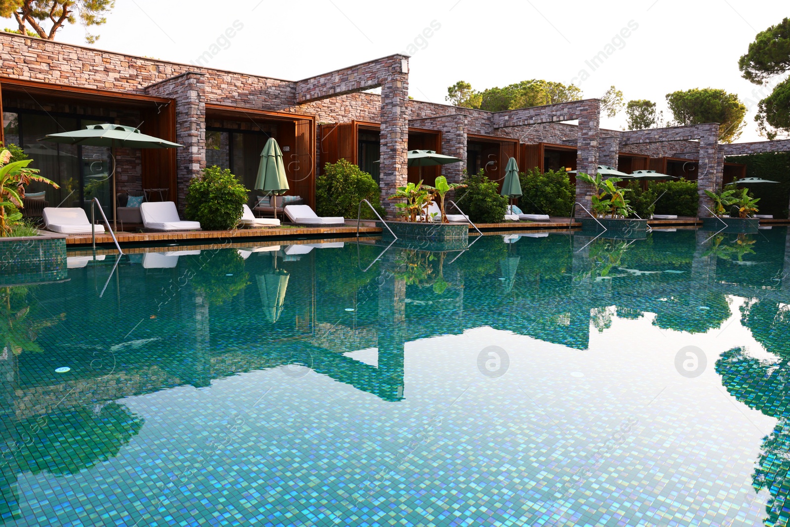 Photo of Outdoor swimming pool with umbrellas and sunbeds at resort