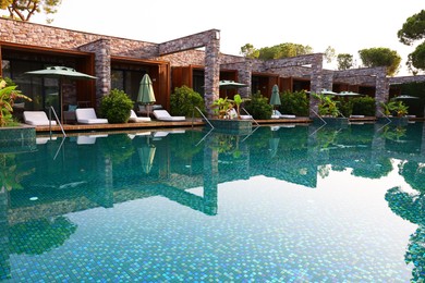 Outdoor swimming pool with umbrellas and sunbeds at resort