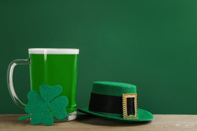 Green beer, hat and clover on wooden table. St. Patrick's Day celebration