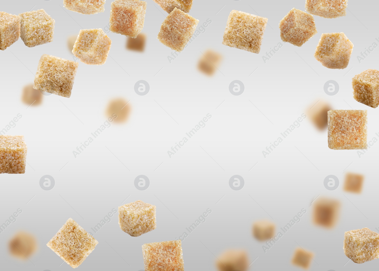 Image of Brown cane sugar cubes falling on grey gradient background