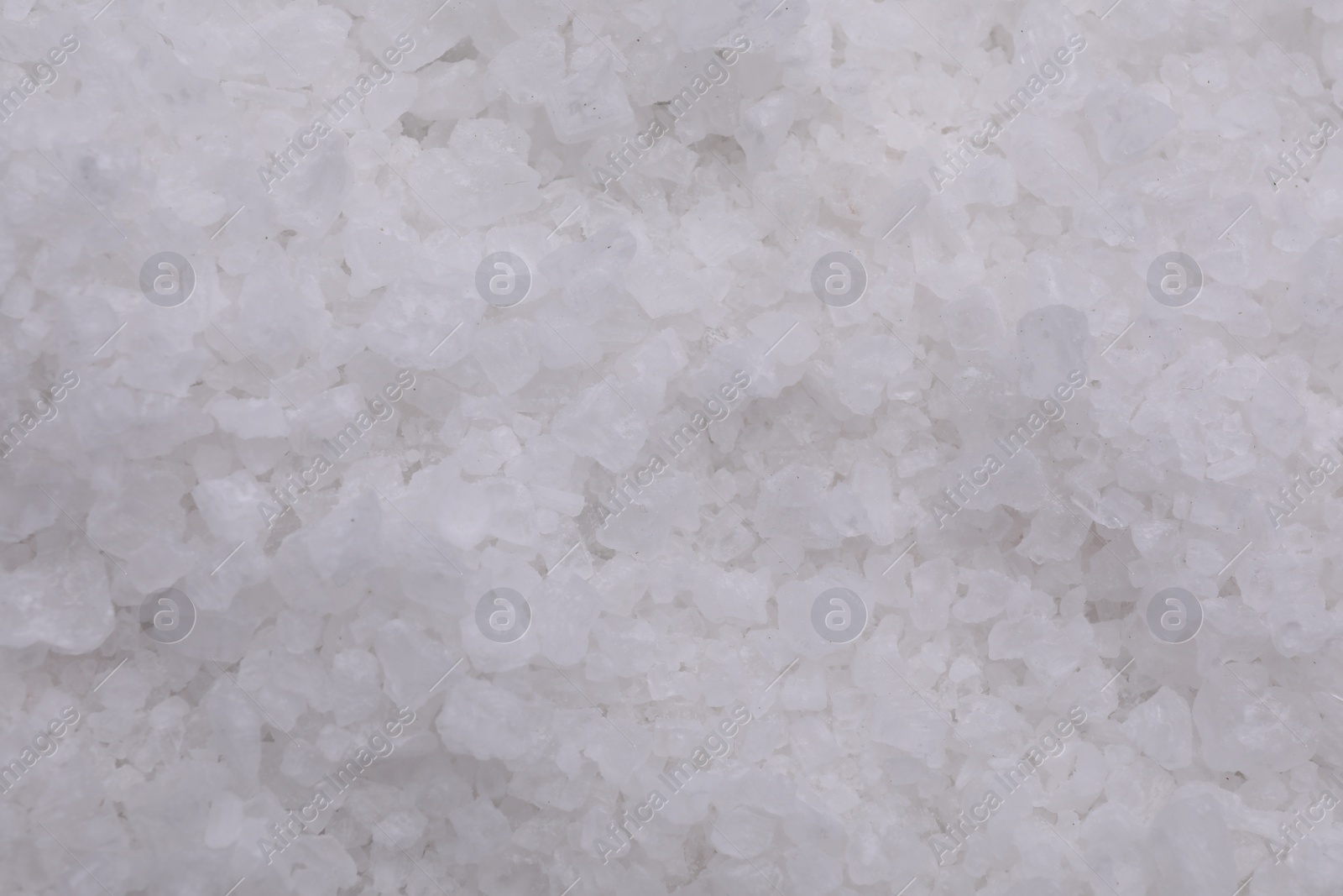 Photo of White sea salt as background, top view