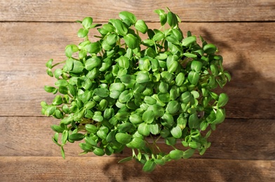 Photo of Fresh organic microgreen on wooden table, top view