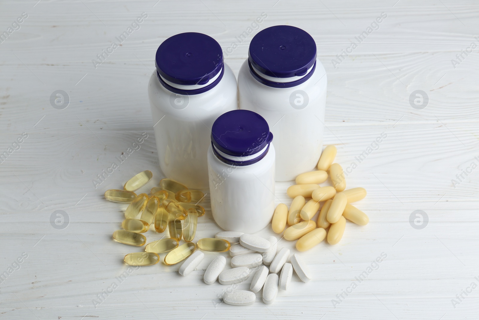 Photo of Medical bottles and pills on white wooden table