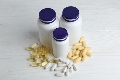 Medical bottles and pills on white wooden table