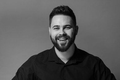 Portrait of handsome bearded man on grey background. Black and white effect