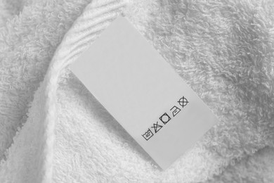 Photo of Clothing label on white fluffy towel, top view