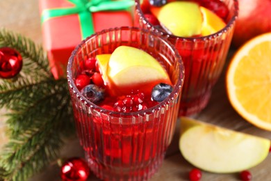 Photo of Aromatic Christmas Sangria drink in glasses on table, closeup