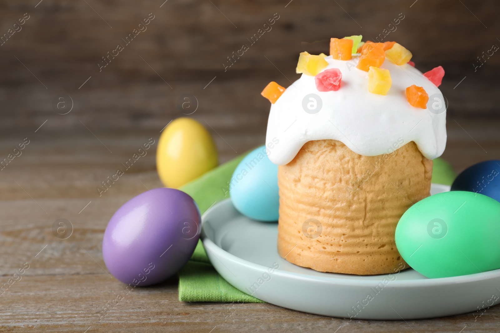 Photo of Traditional decorated Easter cake and colorful eggs on wooden table, closeup. Space for text