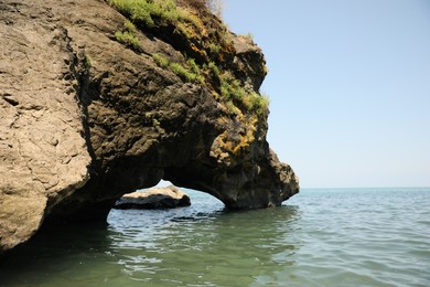 Picturesque view of rock and sea on sunny day