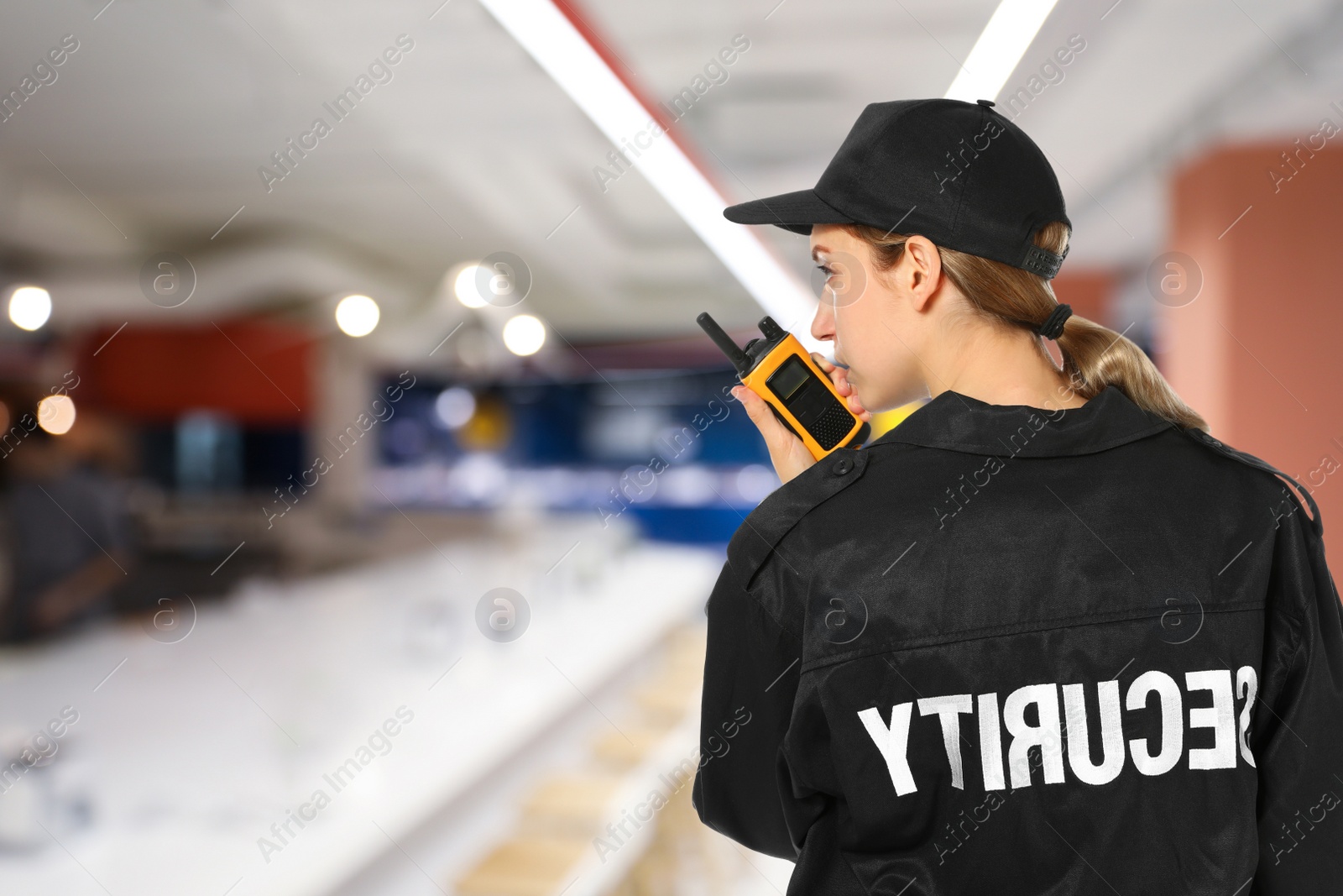 Image of Security guard using portable radio transmitter in wholesale market, space for text