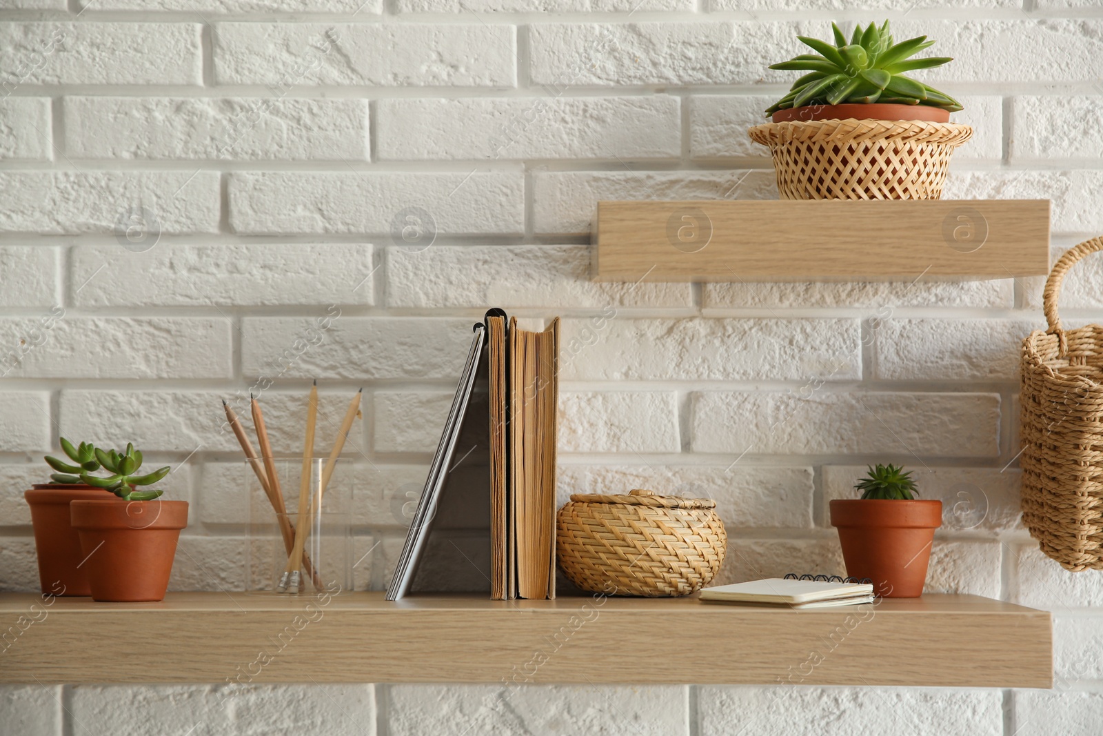 Photo of Shelves with decorative elements on white brick wall. Interior design