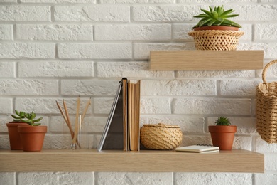 Shelves with decorative elements on white brick wall. Interior design