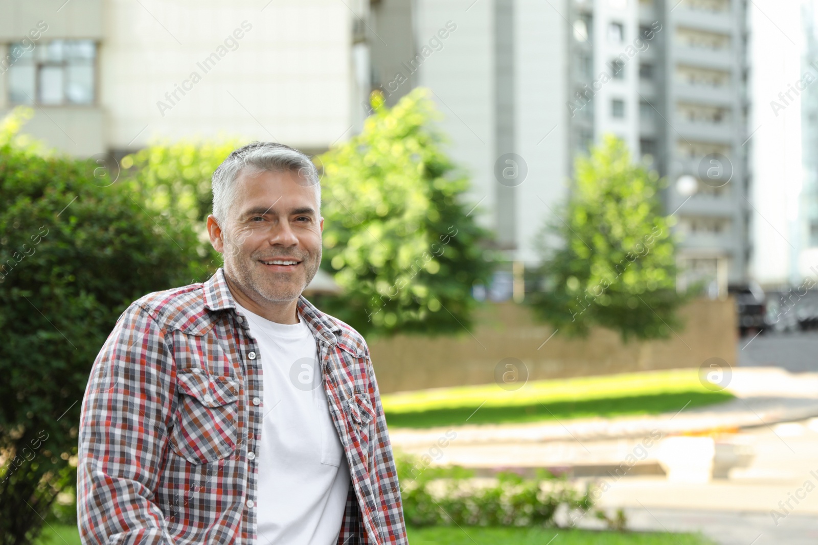 Photo of Portrait of handsome mature man in park. Space for text