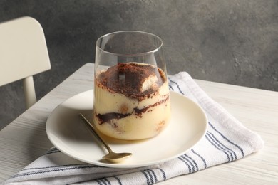 Photo of Delicious tiramisu in glass on white wooden table