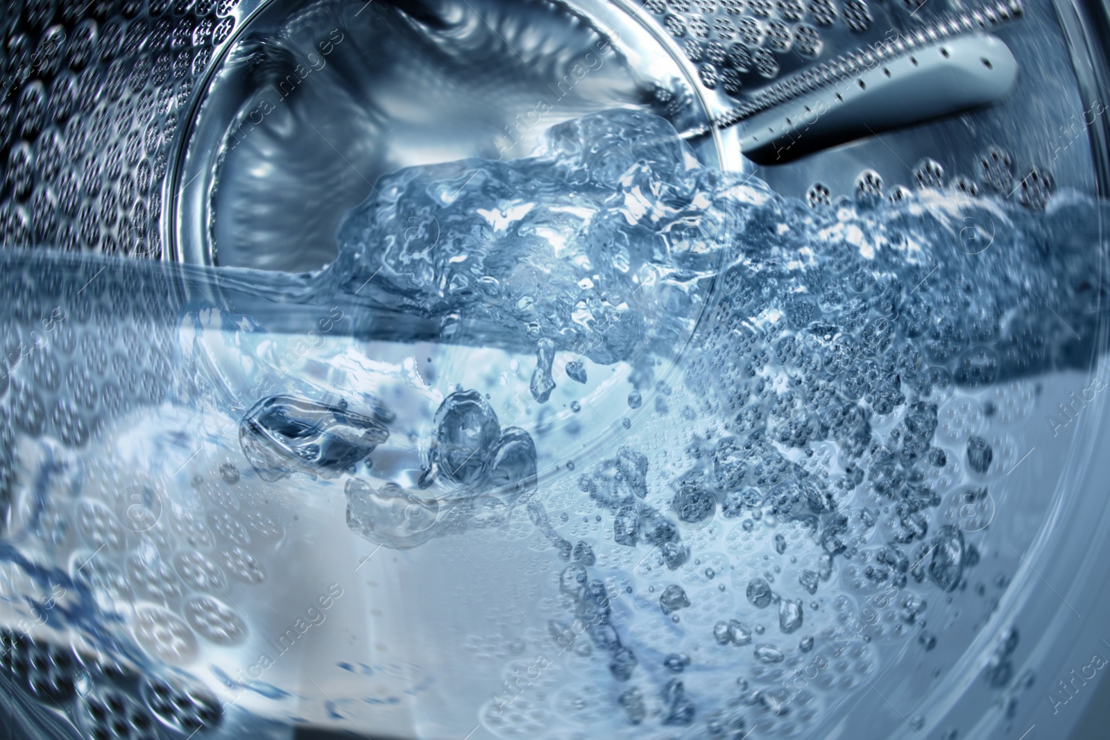 Image of Washing machine drum with water, closeup view
