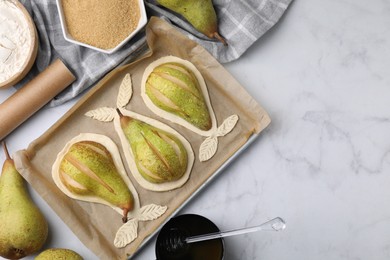 Photo of Tray with raw dough, fresh pears and honey on white marble table, flat lay. Space for text
