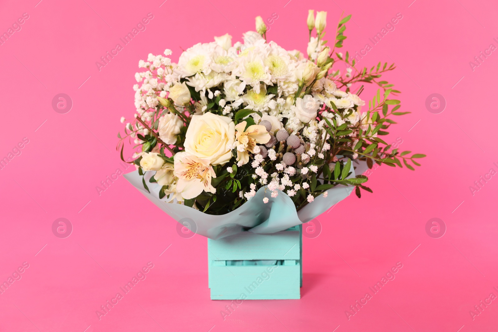 Photo of Beautiful bouquet of flowers in decorative crate on color background