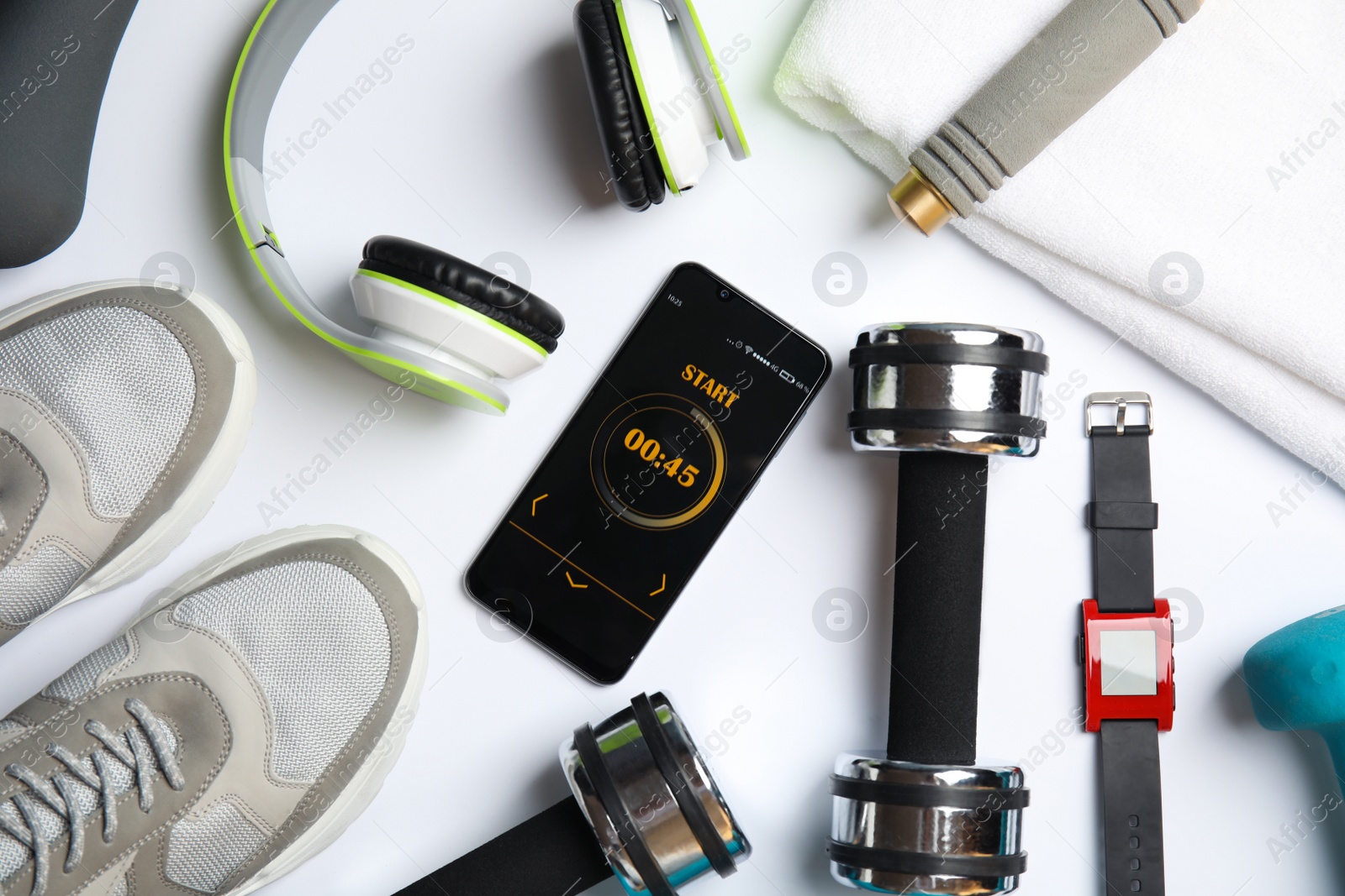 Photo of Flat lay composition with fitness equipment and smartphone on white background