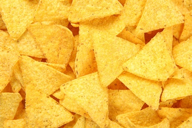 Photo of Tasty Mexican nachos chips as background, top view