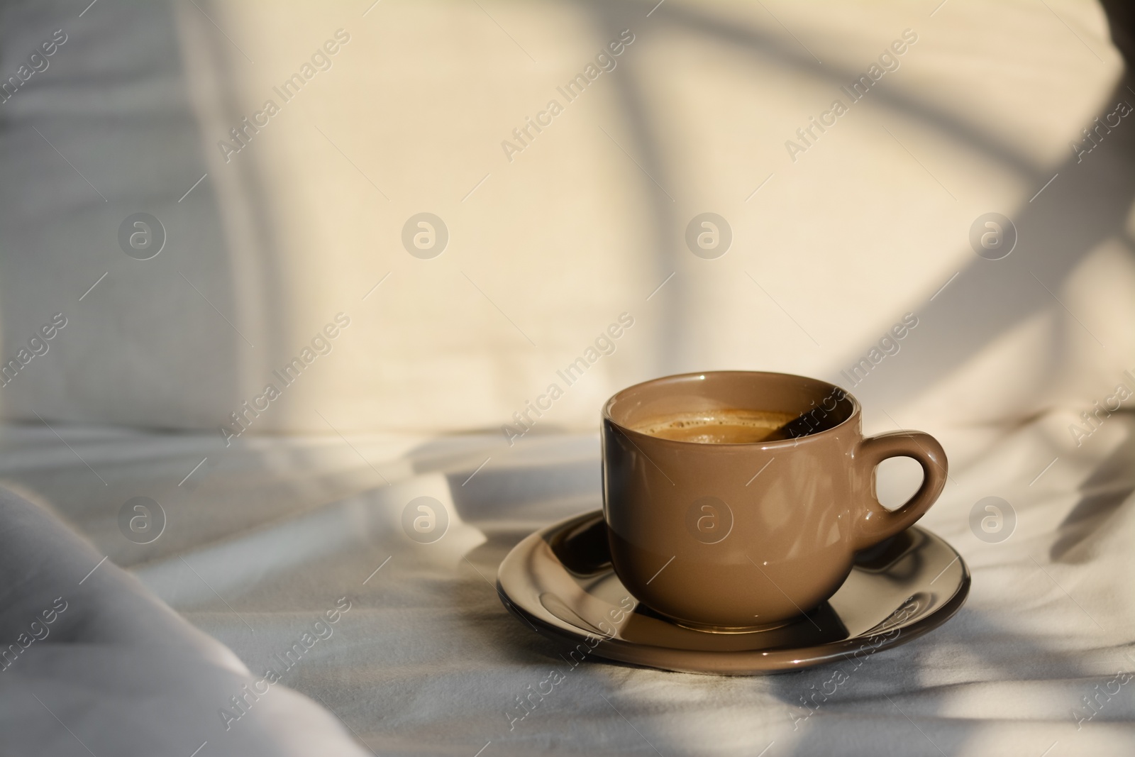 Photo of Aromatic morning coffee on bed, space for text