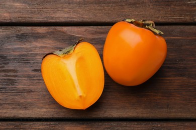 Photo of Delicious ripe persimmons on wooden table, flat lay