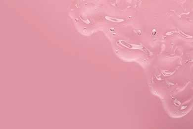 Photo of Transparent cleansing gel on light pink background, top view with space for text. Cosmetic product