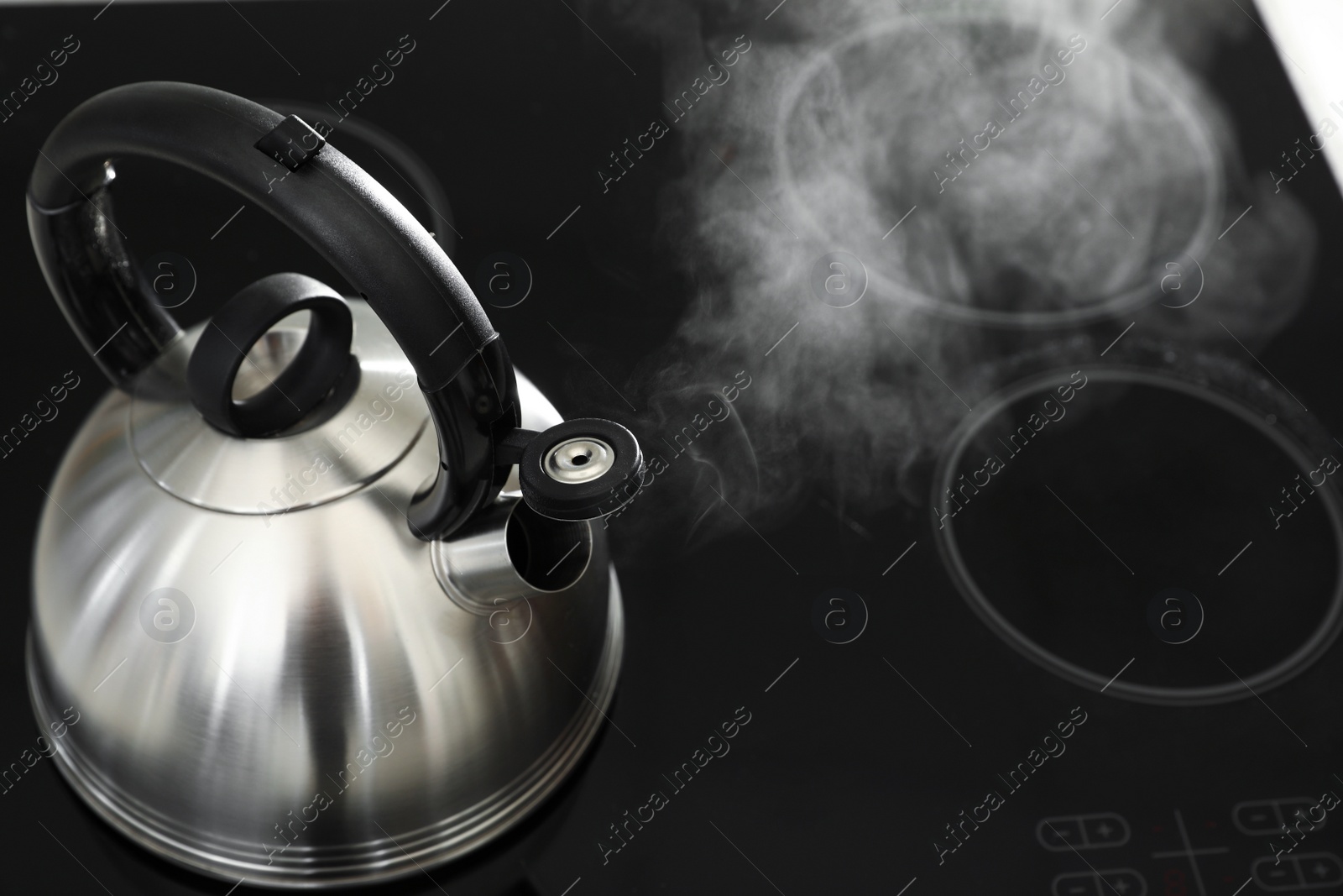 Photo of Modern kettle with whistle on stove, above view. Space for text