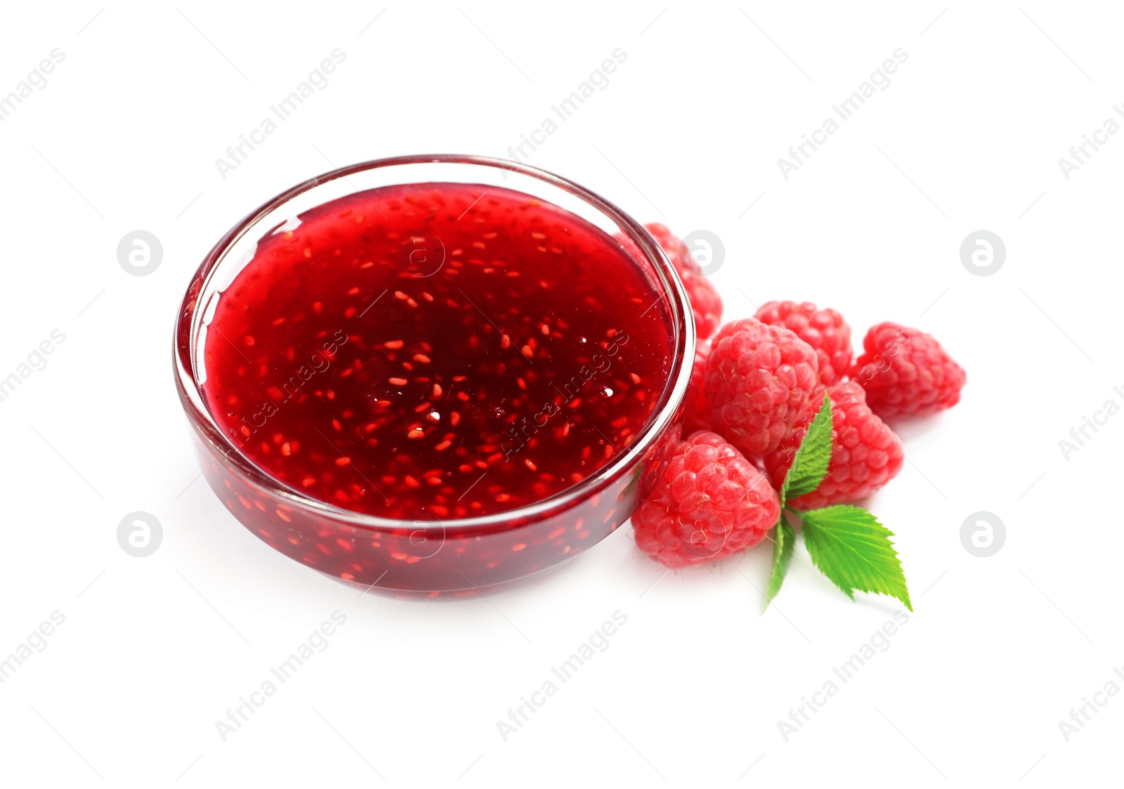 Photo of Bowl of sweet jam with ripe raspberries and green leaves on white background