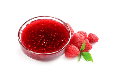 Photo of Bowl of sweet jam with ripe raspberries and green leaves on white background