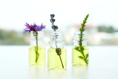 Photo of Composition with essential oils and flowers on table