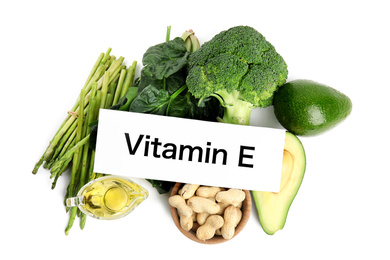 Photo of Card with phrase Vitamin E and different products on white background, top view