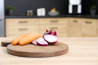 Photo of Fresh vegetables on wooden table in kitchen. Space for text