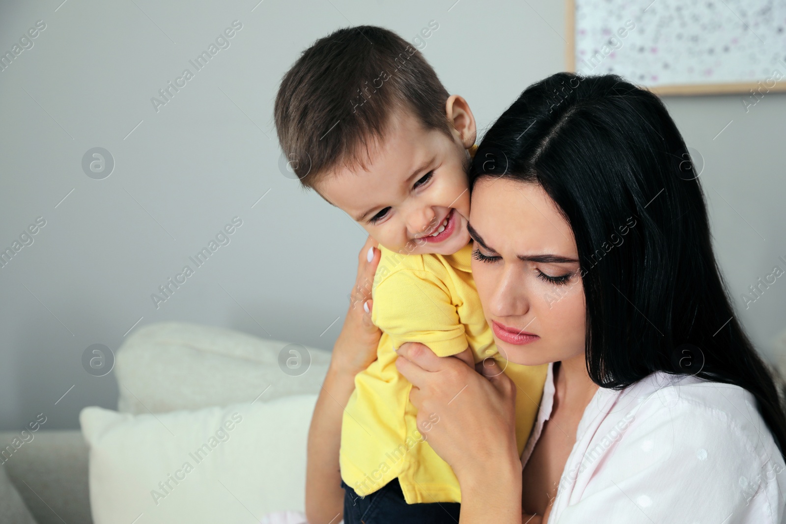 Photo of Depressed single mother with child at home, space for text