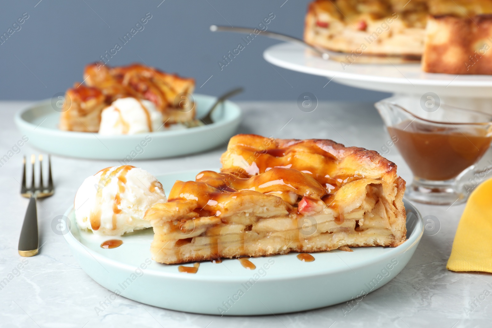 Photo of Slice of traditional apple pie with ice cream served on light marble table