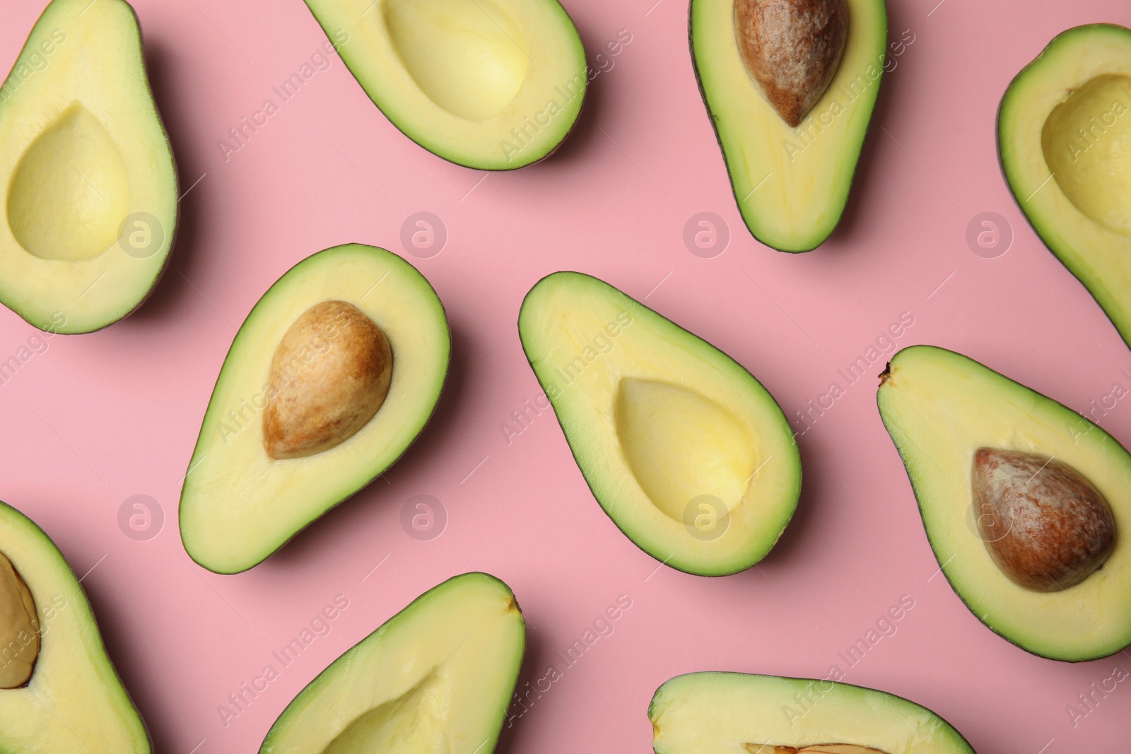 Photo of Cut fresh ripe avocados on pink background, flat lay