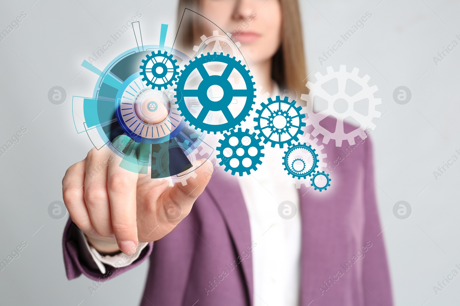 Image of Young woman touching gear mechanism on light grey background, closeup