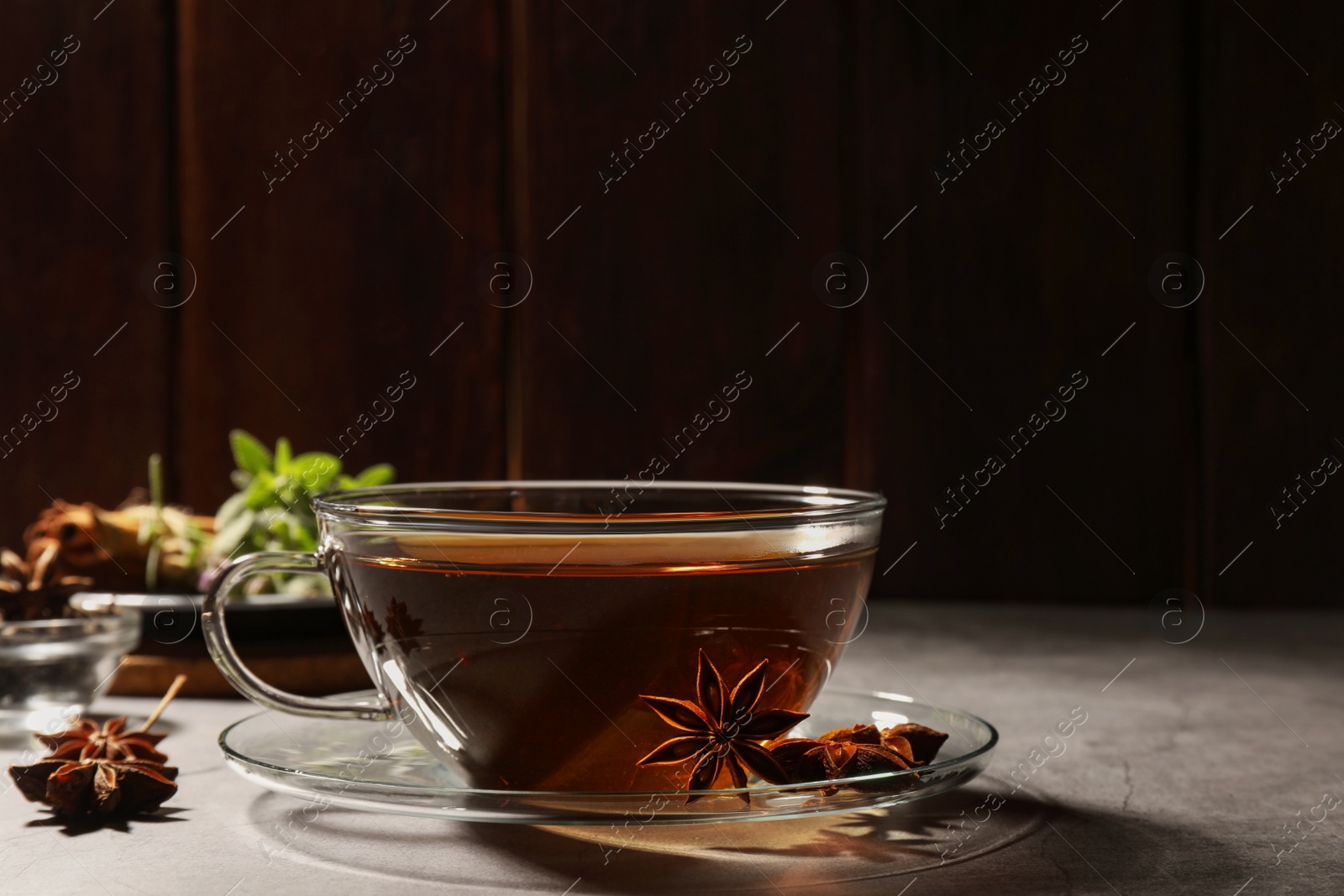 Photo of Aromatic tea with anise stars on light grey table. Space for text