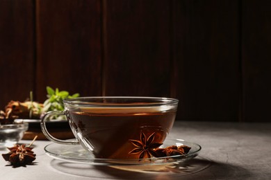 Photo of Aromatic tea with anise stars on light grey table. Space for text