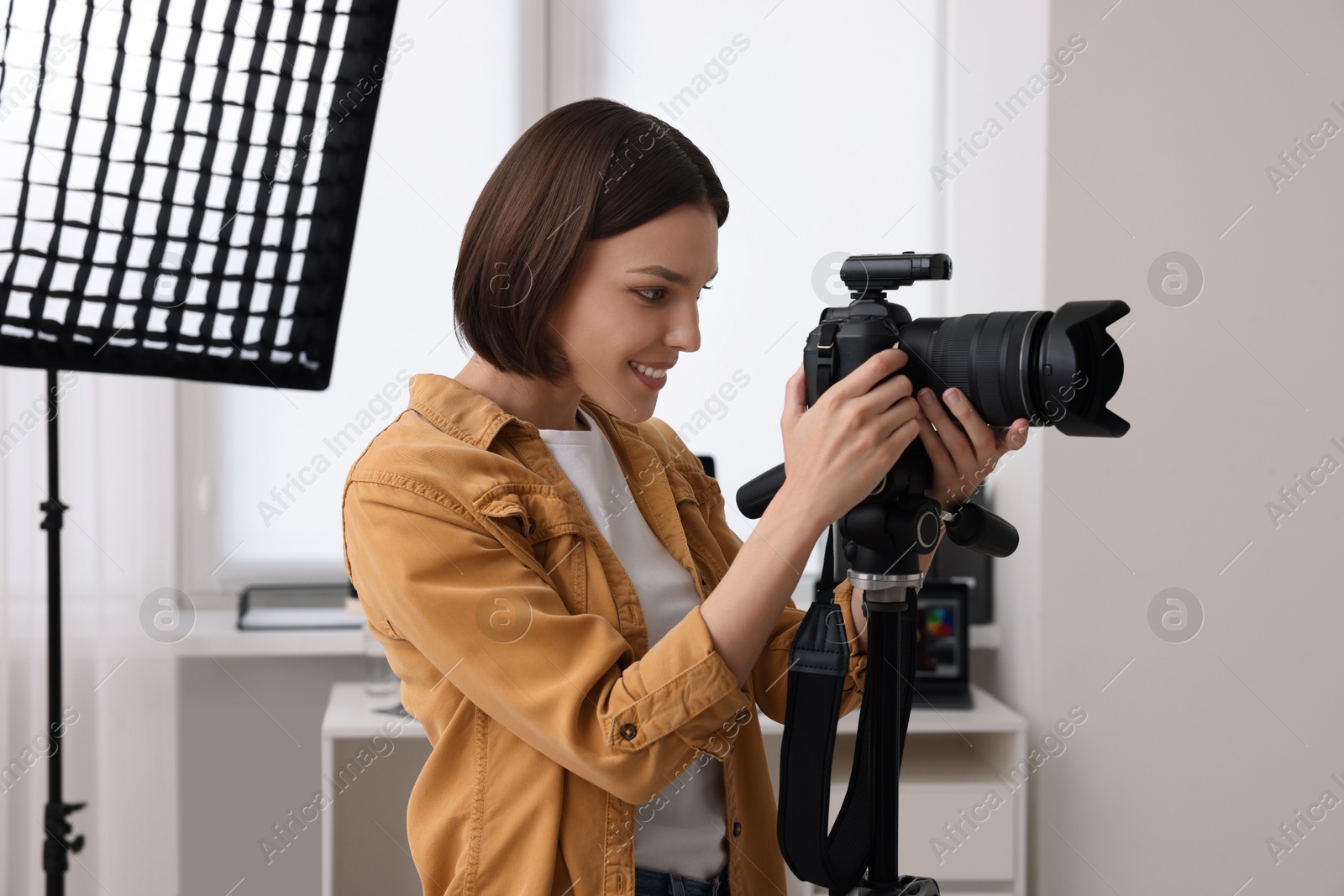 Photo of Professional photographer working with camera in modern photo studio