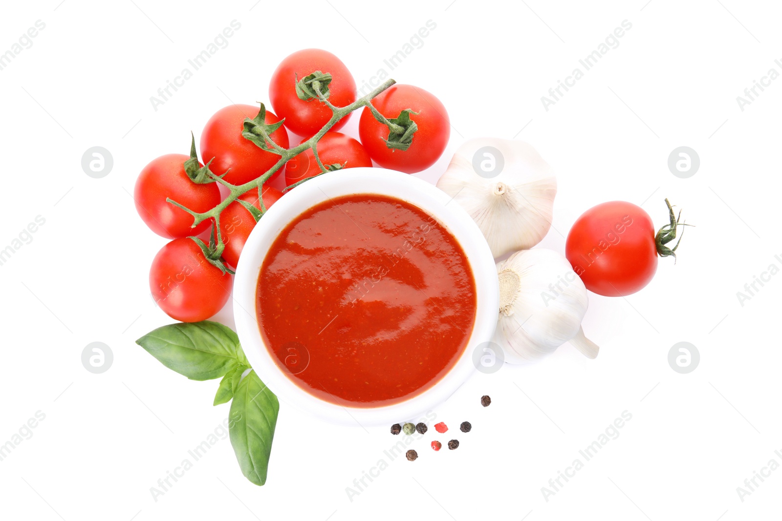 Photo of Bowl of tomato sauce and vegetables isolated on white, top view