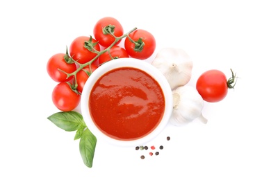 Photo of Bowl of tomato sauce and vegetables isolated on white, top view