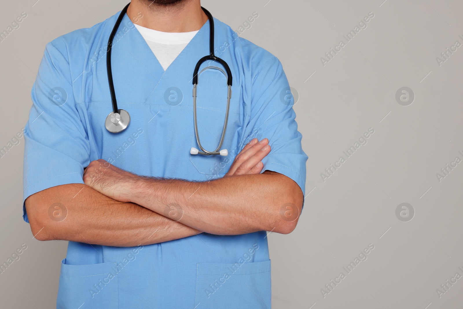 Photo of Doctor with stethoscope on light grey background, closeup